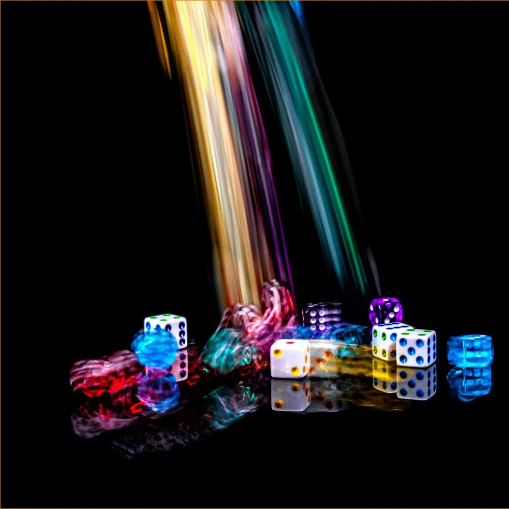 Colourful dice tumbling in streaks of light on a dark background